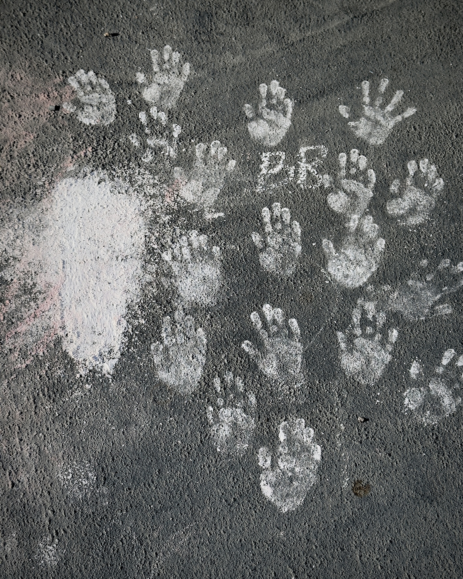 Children's handprints stamped in chalk.